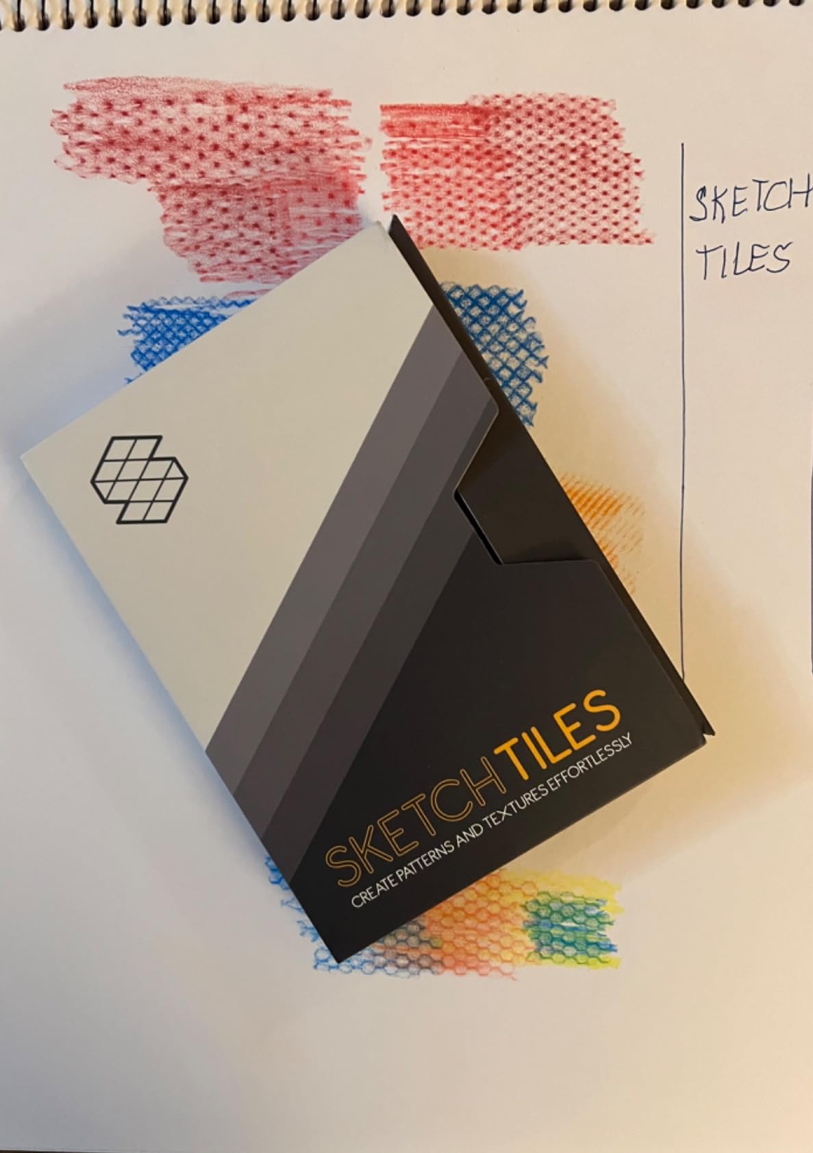 SketchTiles packaging beside colored texture swatches in a sketchbook.
